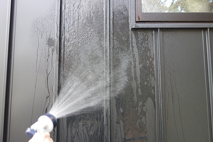 ゼロキューブ(ZERO-CUBE)のガルバリム鋼板の外壁を水で洗い流す写真