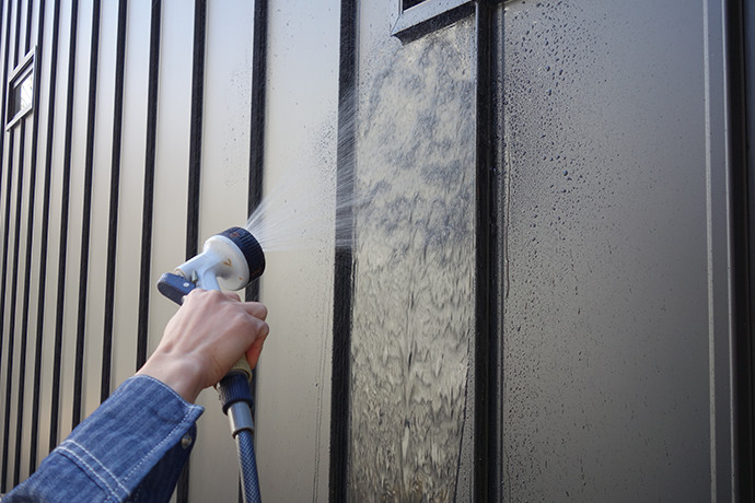 ゼロキューブ(ZERO-CUBE)のガルバリム鋼板の外壁を水で洗い流している様子